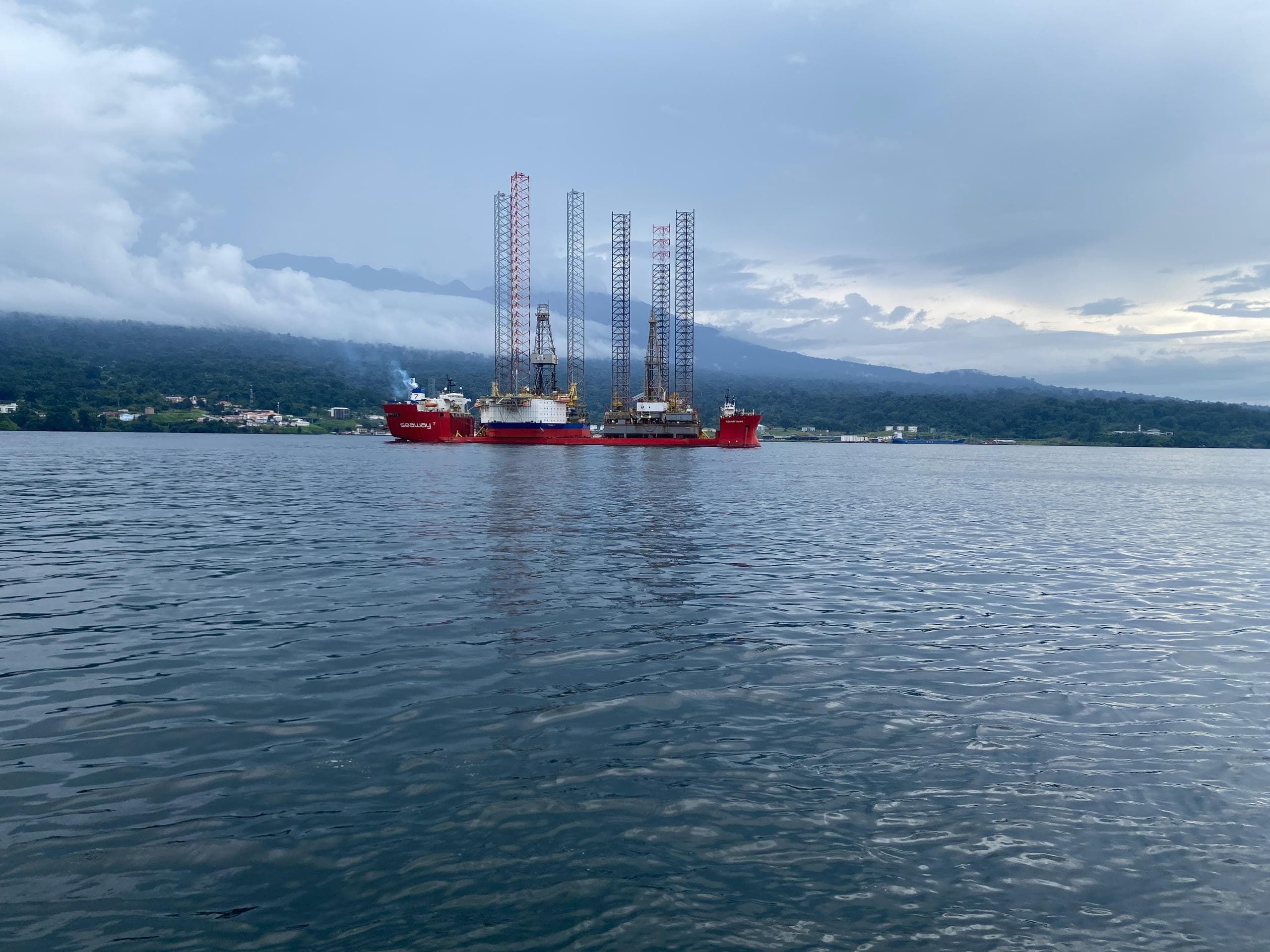 Jack-up rigs under transport at dusk